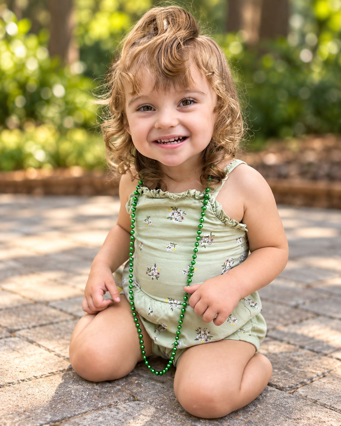 Harper smiling in a soft green outfit and green beads